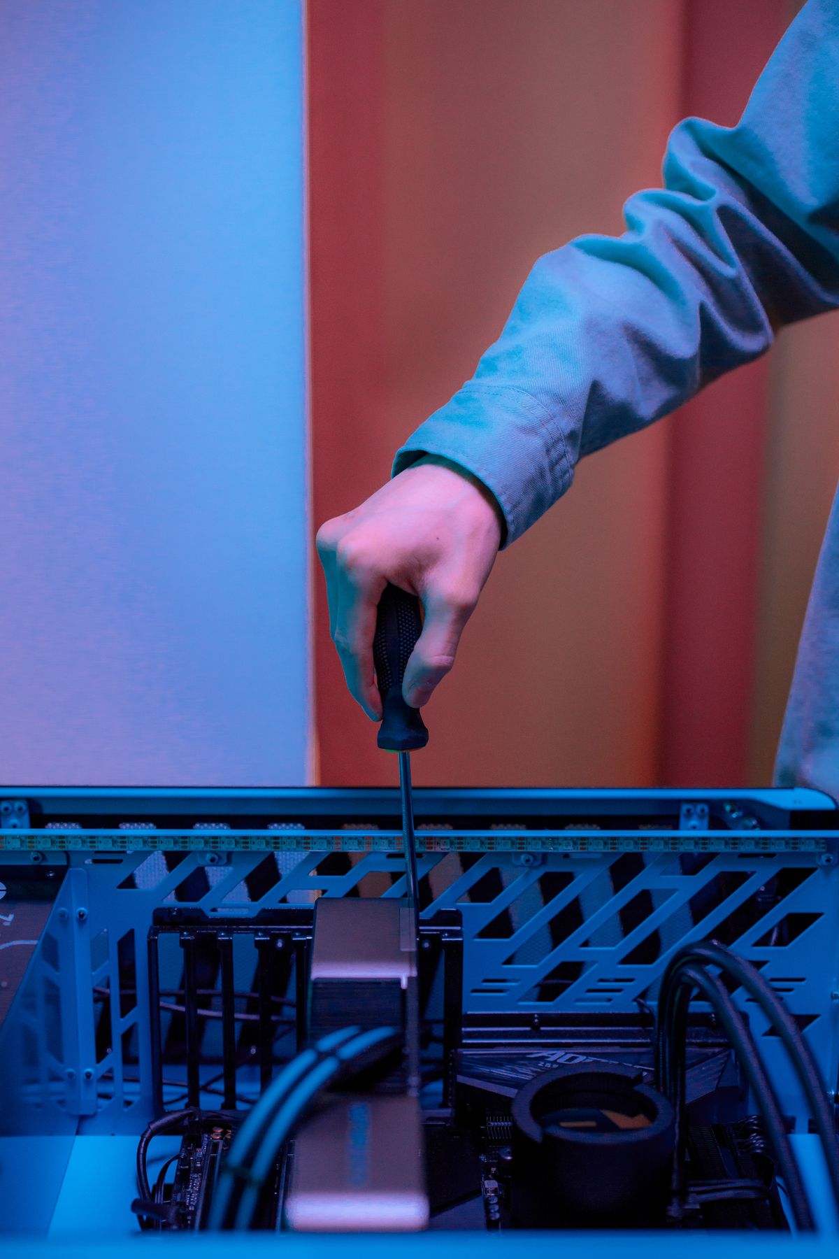 Hands working inside an open PC case with a screwdriver