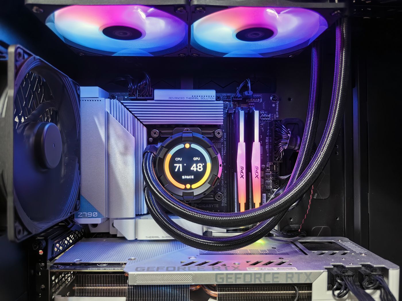 A gaming PC with a screen on the cooler showing live temperatures