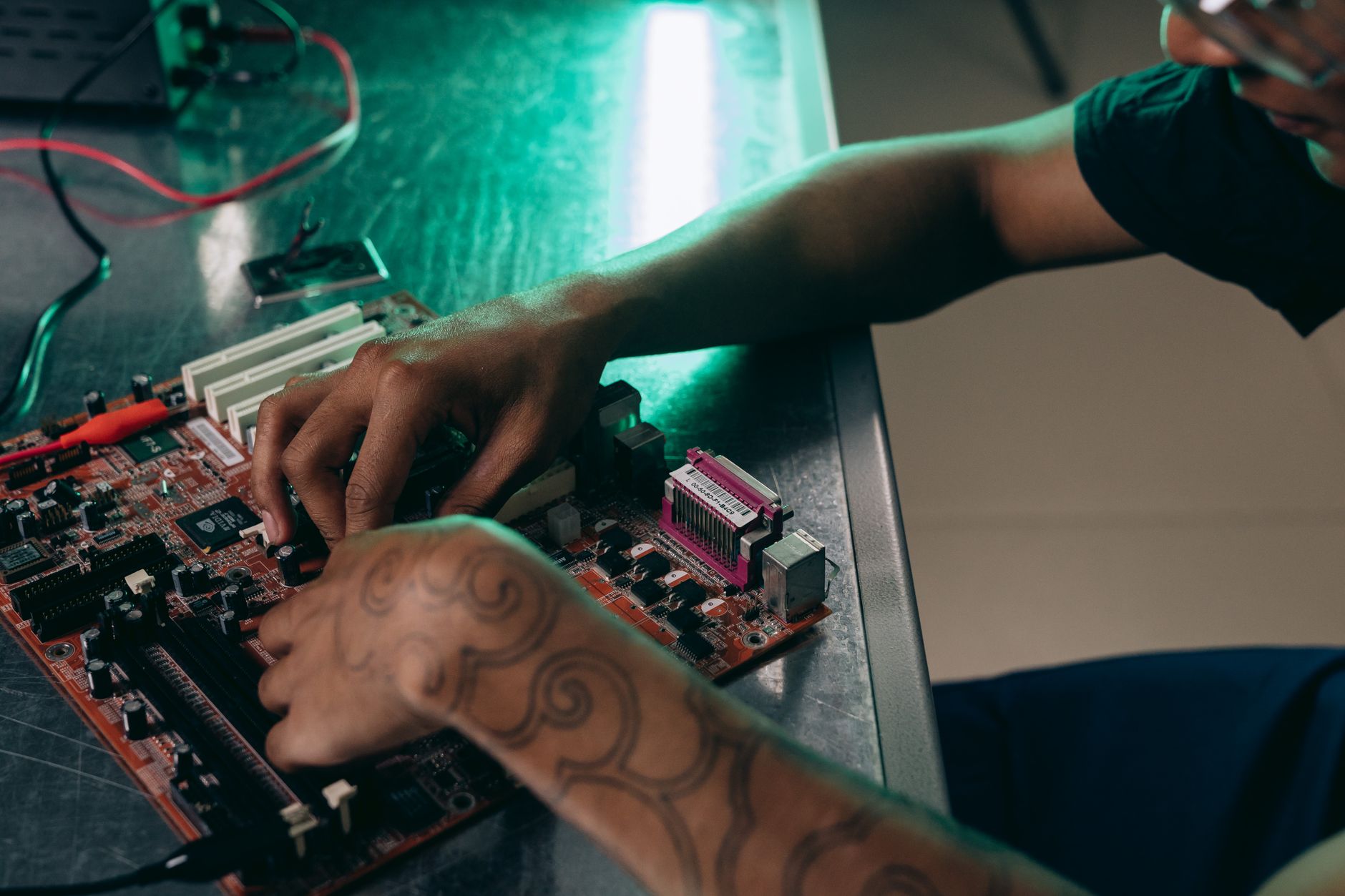 Hands working on a circuit board at the bench